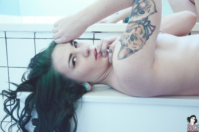 Une brune tatouée nue dans sa salle de bain