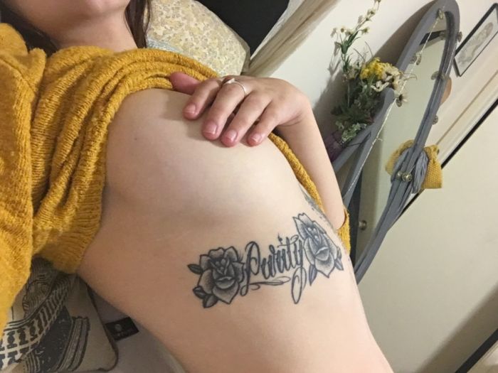 Une fille se fait tatouer « Purity » sous le seins droit